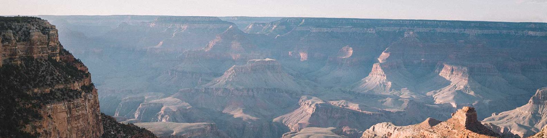 the sun shines upon the rippling walls of the Grand Canyon South Rim