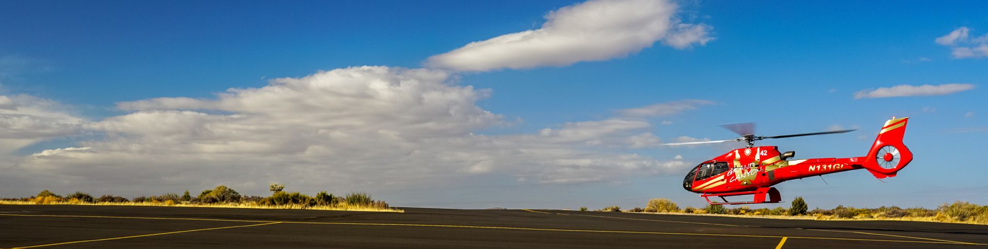 a red helicopter takes off from the Grand Canyon West