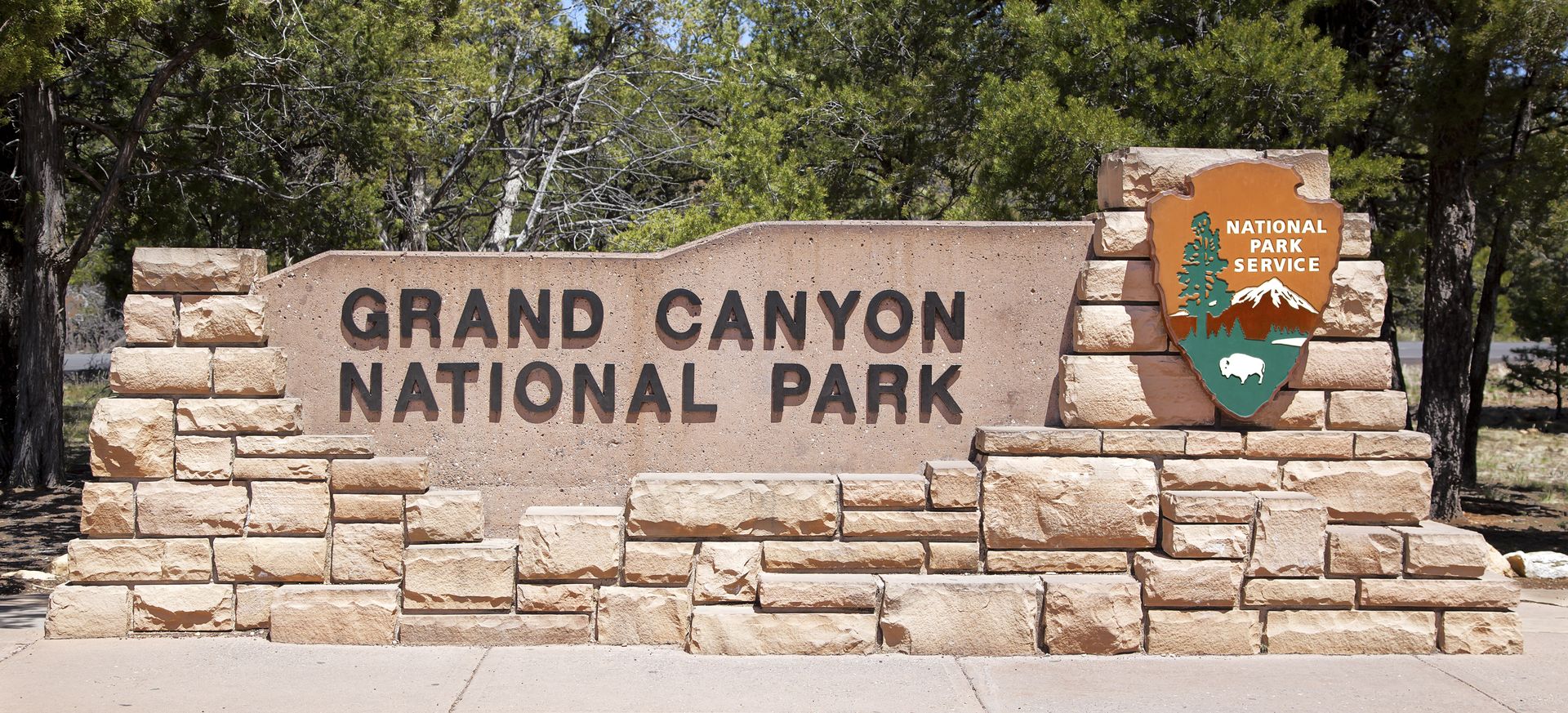 The entrance sign for the Grand Canyon National Park in bright sunlight