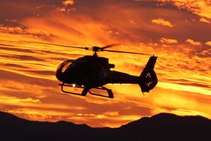 a silhouette of the grand canyon at sunset with a bright orange sky in the background