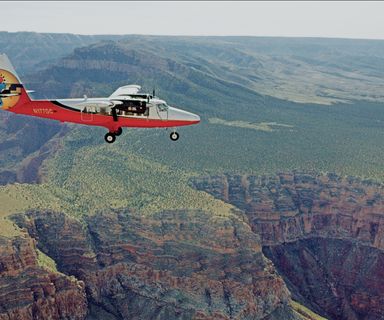 A Twin Otter touring airplane flies over the Kaibab Forest