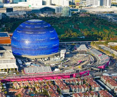 a turn in the las vegas race track and the MSG Sphere seen from a helicopter