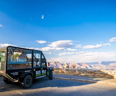 an open air touring vehicle parked at a Grand Canyon National Park lookout point