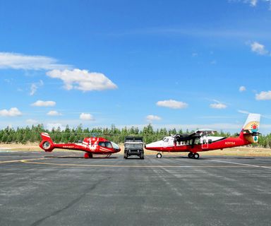 A Papillon helicopter and a Buck Wild Hummer parked the Grand Canyon National Park