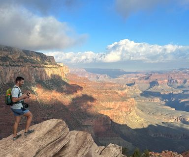 A hiker gazing out into the South Rim while hiking on Grandview Trail