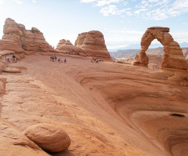 visitors to Arches National Park stand amidst the incredible rock formations