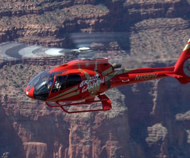 a red helicopter lands at the grand canyon air terminal after a tour over the South Rim