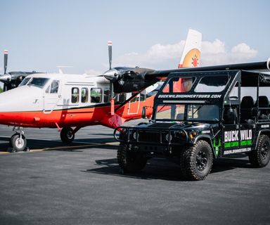 A Twin Otter airplane and a Buck Wild Hummer vehicle seen together on Papillon's tarmac