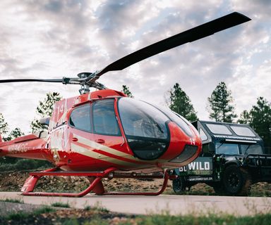 A Buck Wild Hummer and a Papillon Helicopter parked together