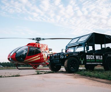 An Ecostar helicopter and a Buck Wild Hummer parked at the South Rim