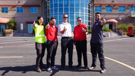 papillon helicopters employees smile and give a thumbs-up sign in front of the air terminal