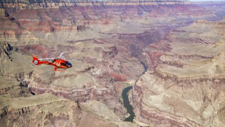a Grand Canyon helicopter tour flies over a massive canyon gorge at the South Rim