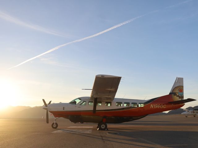 A Cessna Caravan parked on the tarmac at the Boulder City air terminal at sunset