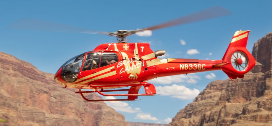 a helicopter tour departs from the Grand Canyon floor and flies through the ancient stone walls