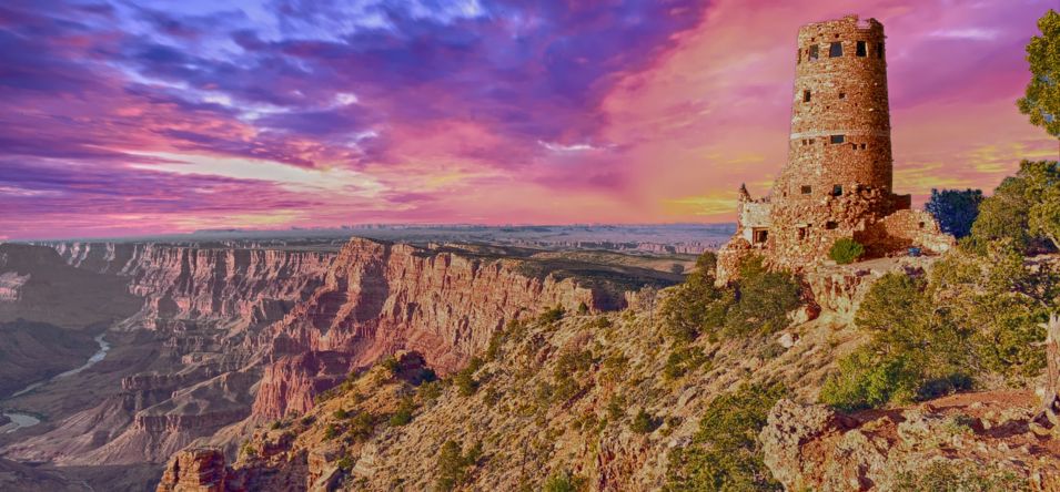 The North Rim Lookout Tower at the Grand Canyon seen under a pink and purple sunset