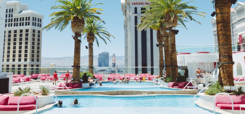 swimming pool area at a Las Vegas casino with Caesar's Palace in the background