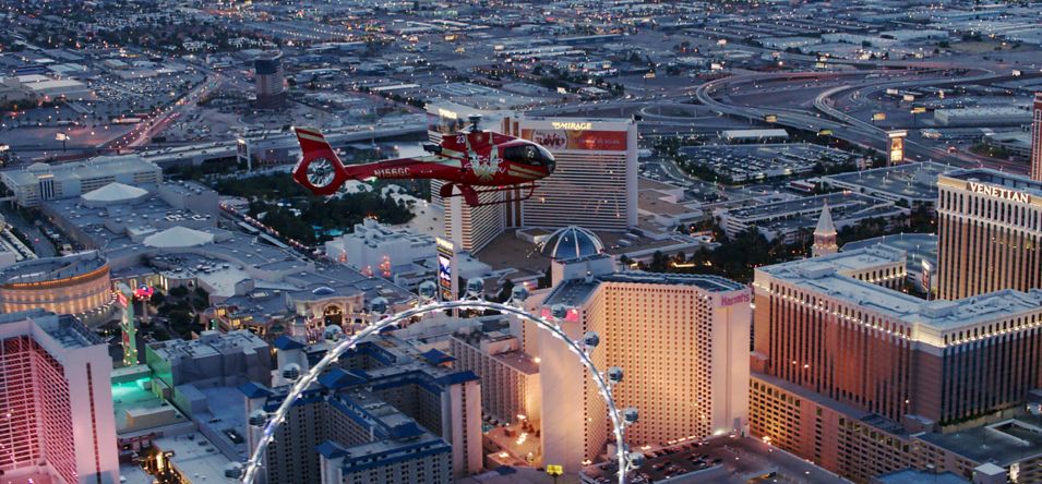 Red helicopter flying over the Las Vegas Strip on sunset
