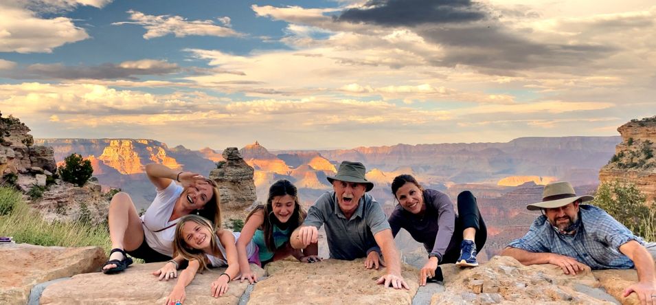 A family pretends to cling to the edge of the Grand Canyon South Rim