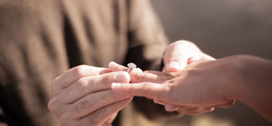 a closeup of an engagement ring is slid onto a woman's finger during a Grand Canyon proposal