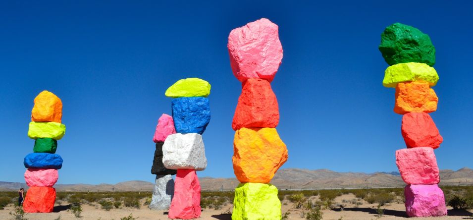 Seven rainbow-colored boulders forming rock towers, standing over 30 feet tall