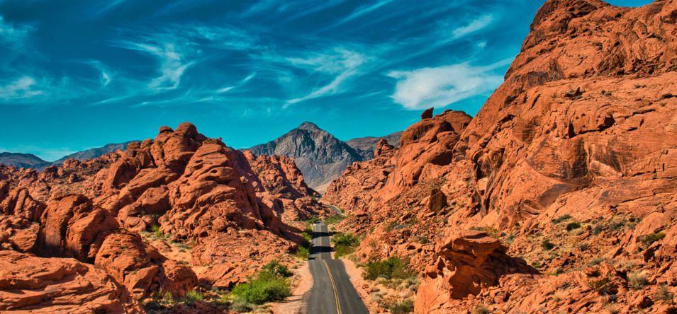 A roadway cuts through the bright red and orange rock formations within Valley of Fire
