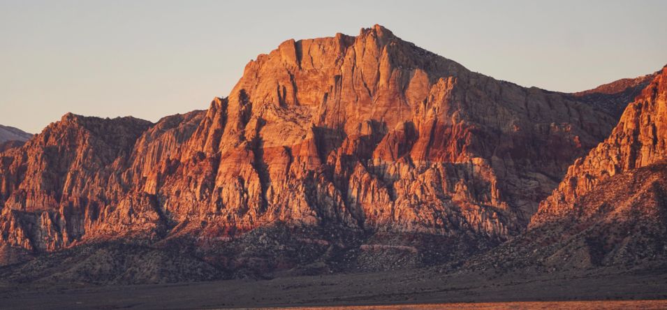 a large mountainous region of Red Rock Canyon seen at sunset