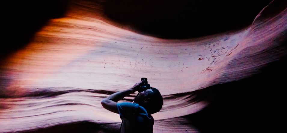 a photographer snaps a photo inside secret antelope canyon