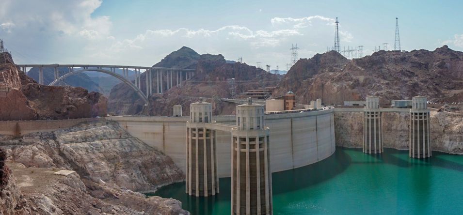 A rear view of Hoover Dam and the turquoise waters surrounding it