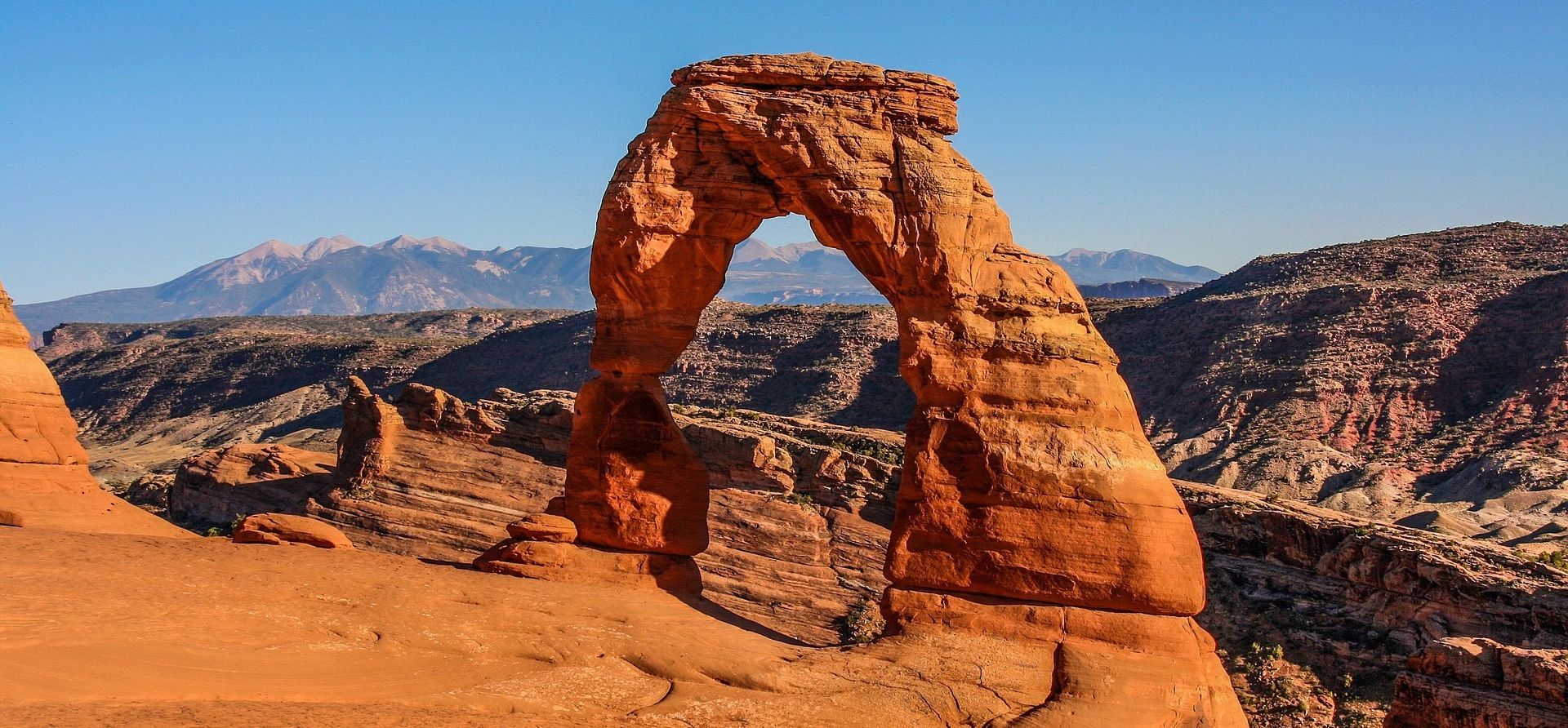 A massive orange sandstone arch found within the depths of Arches National Park
