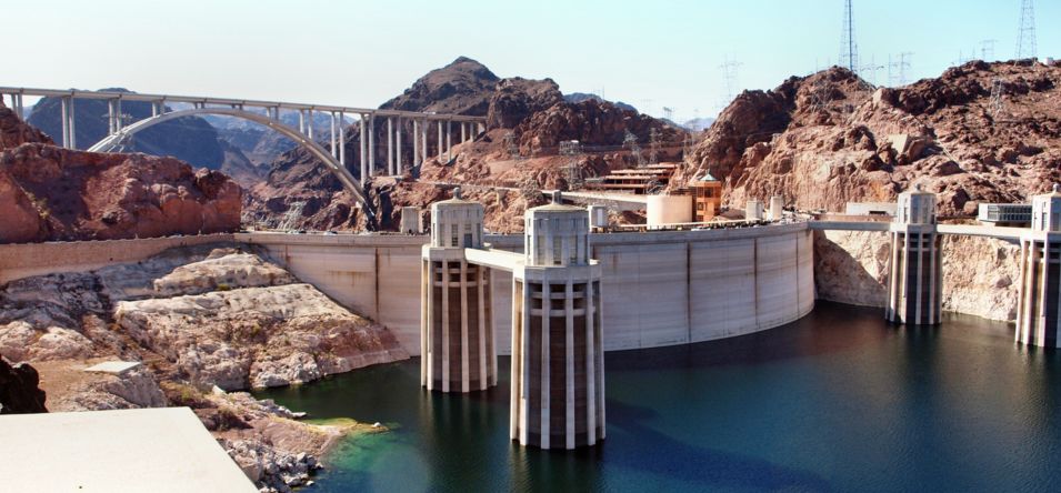 Hoover Dam seen surrounded by water with the memorial bridge in the background