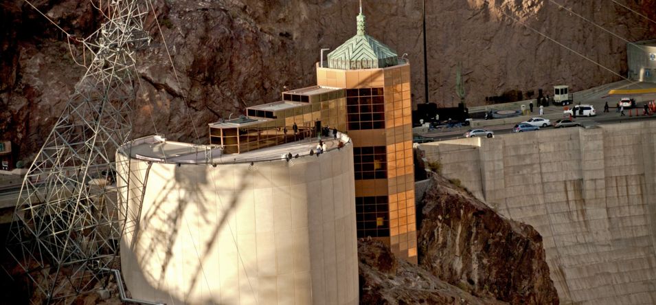 Hoover Dam Visitor Center seen from above, with visitors wandering its balcony