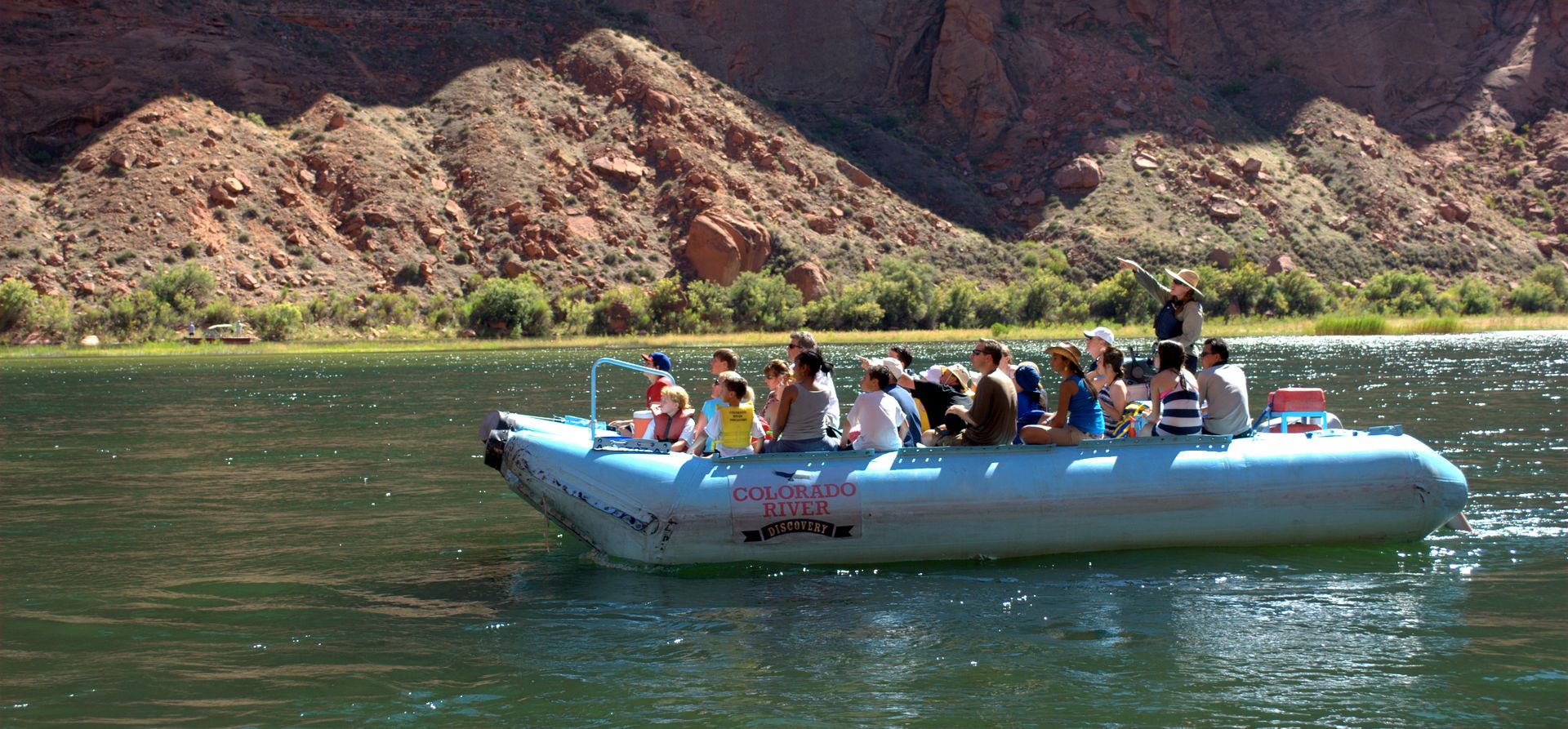 Grand Canyon visitors ride an inflatable raft down the Colorado River