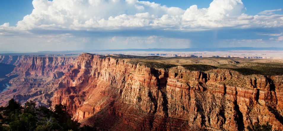 A steep cliff within the Grand Canyon seen with clouds above