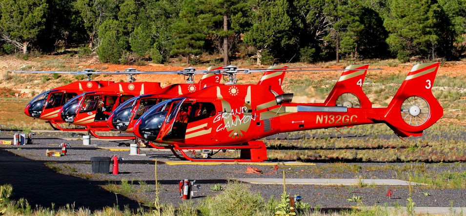 Several touring helicopters parked in a row at the Grand Canyon Airport