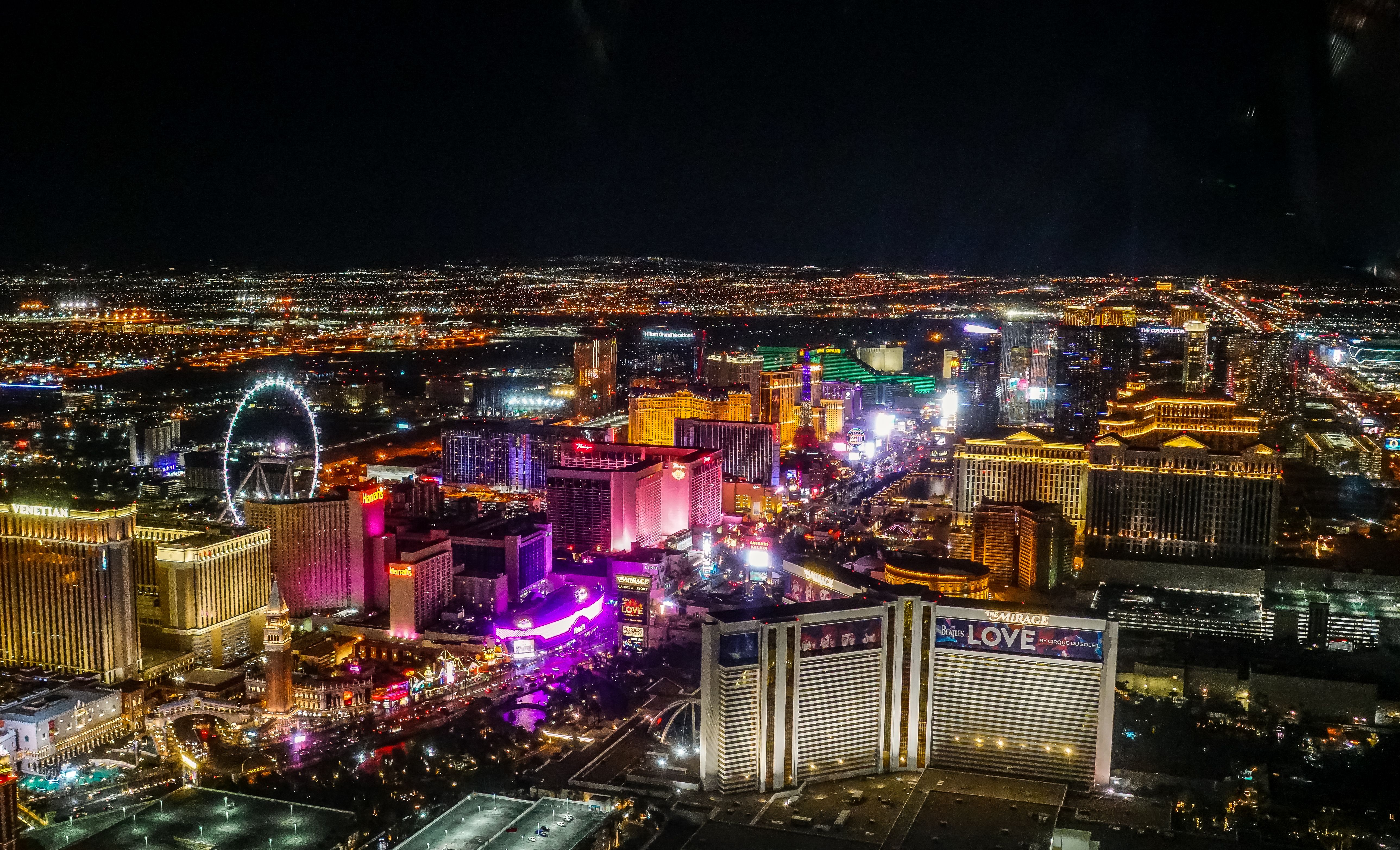 an aerial view of the Las Vegas Strip casinos illuminated radiantly against the night sky