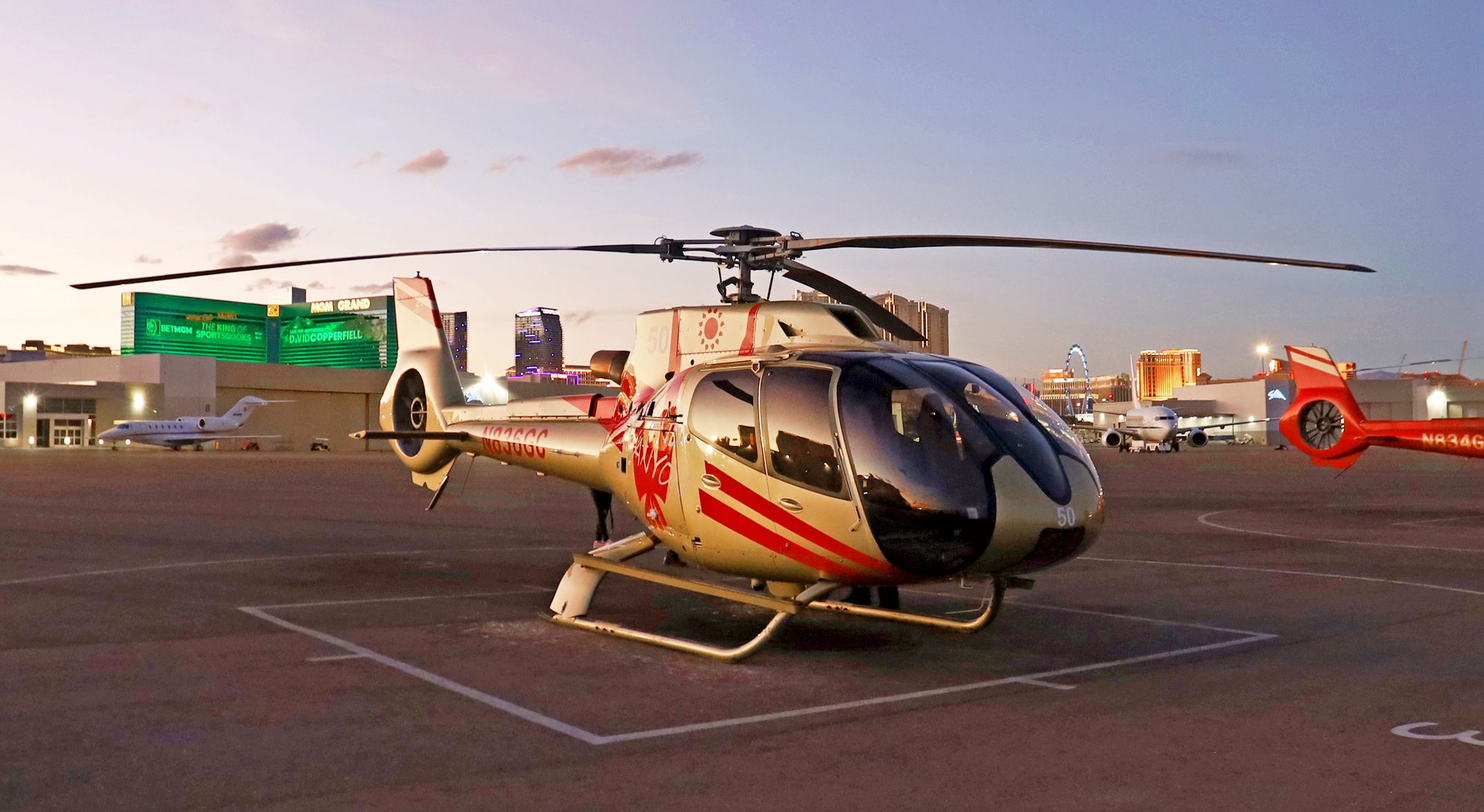 A Las Vegas sightseeing helicopter sits on the tarmac at the Strip air terminal at sunset