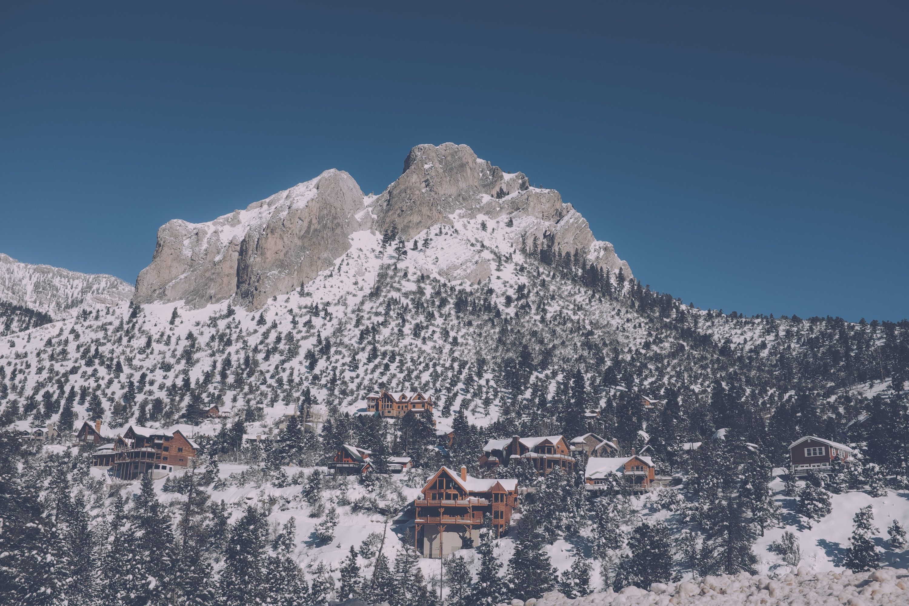 The snow-coated Mount Charleston mountain range with small cabins at its base