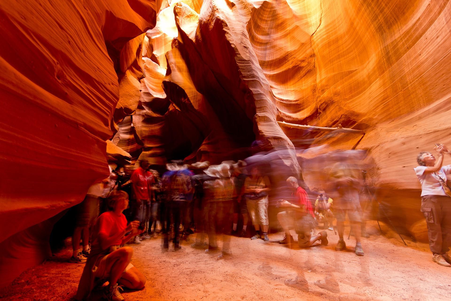 A long exposure shot of several visitors wandering the depths of Antelope Canyon