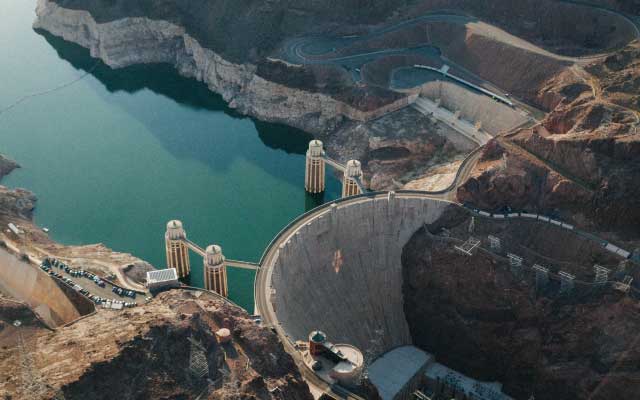 An aerial photo of the Hoover Dam with the Colorado River behind it.